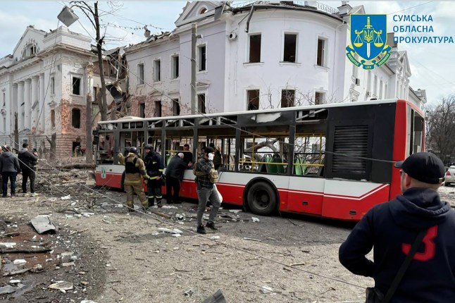 This handout photograph taken and released by Ukraine's Sumy Region Prosecutor's Office on April 13, 2025, Ukrainian law enforcement officers working as local residents are evacuated from a destroyed bus at the site of a missile attack in Sumy, northeastern Ukraine, amid the Russian invasion of Ukraine. A Russian ballistic missile attack on the centre of Ukraine's city of Sumy on April 13, 2025, killed at least 21 people and wounded 20 others, Ukraine's state emergency service said. (Photo by Handout / SUMY REGION PROSECUTOR'S OFFICE / AFP) / RESTRICTED TO EDITORIAL USE - MANDATORY CREDIT "AFP PHOTO / SUMY REGION PROSECUTOR'S OFFICE" - NO MARKETING NO ADVERTISING CAMPAIGNS - DISTRIBUTED AS A SERVICE TO CLIENTS (Photo by HANDOUT/SUMY REGION PROSECUTOR'S OFFICE/AFP via Getty Images)