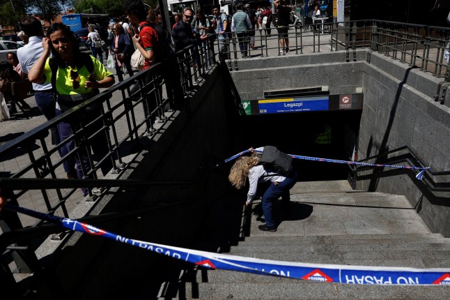 A metro worker passes underneath barricade tape, to enter Legazpi Metro station, after the metro was closed during a power outage, in Madrid, Spain, April 28, 2025. REUTERS/Susana Vera