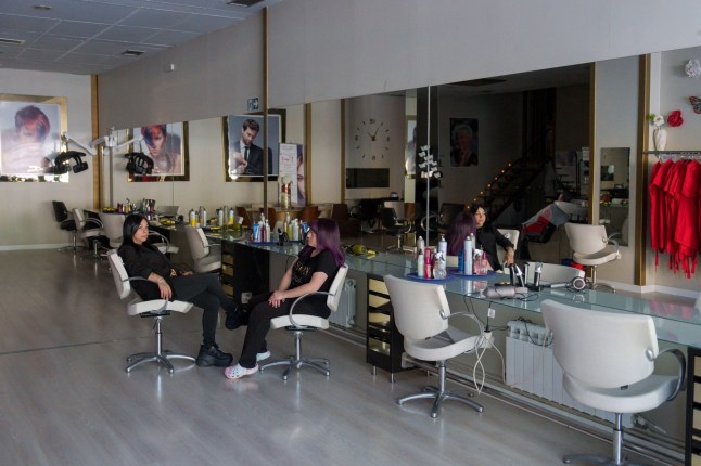 Employees wait in a hair salon in Burgos on April 28, 2025, during a massive power cut affecting the entire Iberian peninsula and the south of France. A "massive" power cut late on April 28, 2025 morning affected the whole of the Iberian peninsula and part of France, according to Portuguese electricity network operator REN. (Photo by CESAR MANSO / AFP) (Photo by CESAR MANSO/AFP via Getty Images)